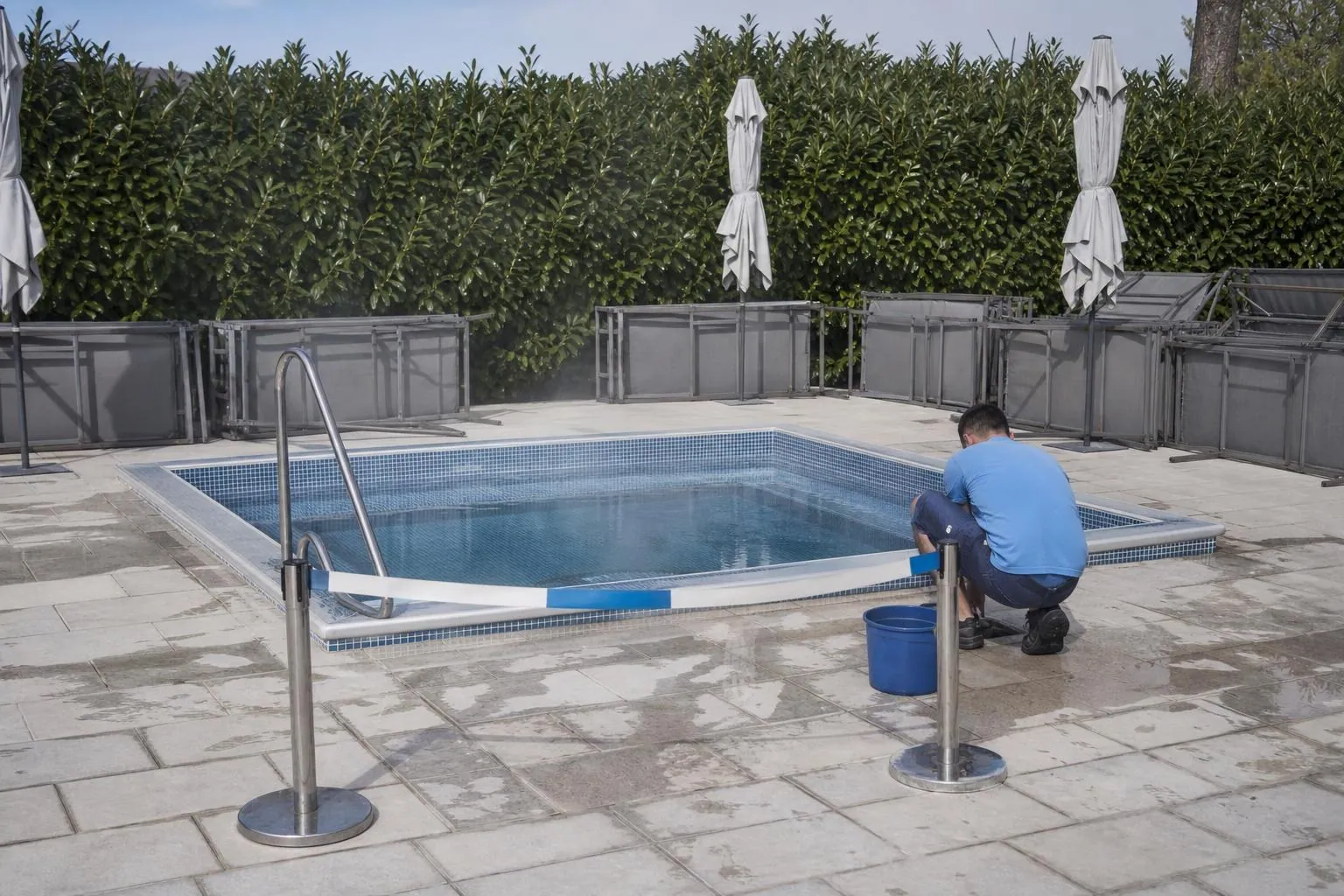 Un bain à remous fermé au public en pleine journée, barrière souple posée devant l’escalier et vapeur à la surface